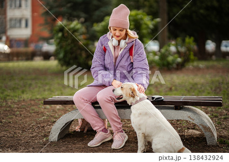 Young woman enjoying park bench with dog Young woman enjoying park bench with dog 138432924