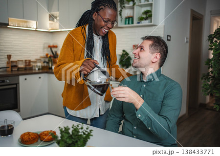 Happy interracial couple enjoying breakfast together in kitchen 138433771