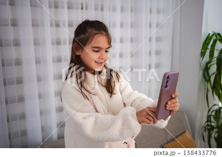 Young girl smiling taking selfie on smartphone 138433776