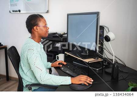 Black woman working from home using computer and keyboard Black woman working from home using computer and keyboard 138434064