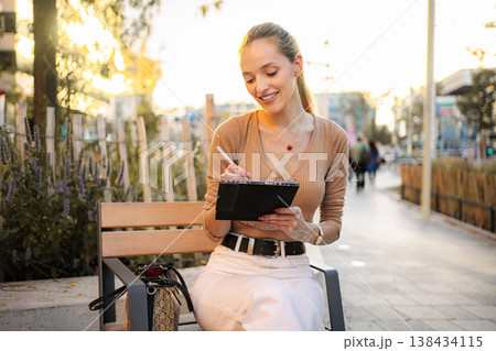 Young woman artist using digital tablet sketching outdoors in Vienna 138434115