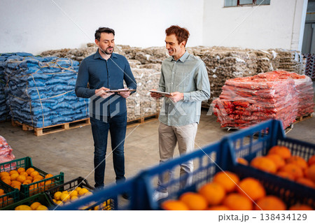 Men inspecting fruit and vegetable stock in warehouse Men inspecting fruit and vegetable stock in warehouse 138434129