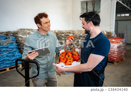 Farmer and manager discussing fresh tomatoes in warehouse Farmer and manager discussing fresh tomatoes in warehouse 138434140