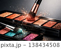 Sparkling eyeshadow palettes with brushes and shimmering glitter dust creating a magical effect 138434508