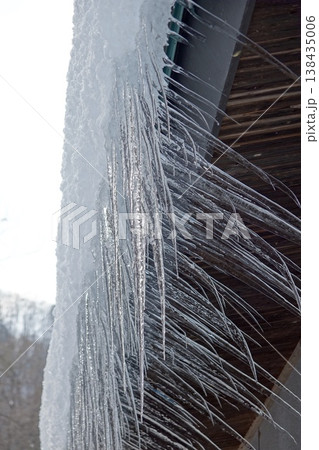 雪の積もった屋根から垂れるつらら 138435006