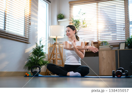 Young woman practicing stretching exercise on yoga mat indoors. Young woman practicing stretching exercise on yoga mat indoors. 138435057