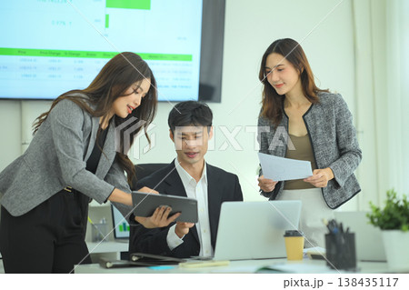 Team discussing strategy around laptop in office Team discussing strategy around laptop in office 138435117