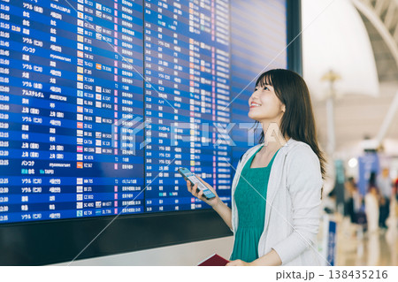 空港で電光掲示板を見る女性　「撮影協力：関西国際空港（KIX）」 138435216