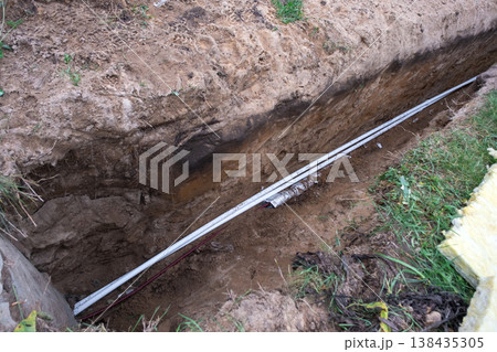 Trench for water pipe installation, digging, underground piping, pipeline insulation, plumbing laying, groundwork for water supply system, site works. Trench for water pipe installation, digging, underground piping, pipeline insulation, plumbing laying, groundwork for water supply system, site works. 138435305