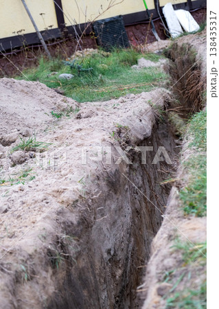 Plumbing trench under wall, insulated supply pipeline, groundwork excavation, utility channel, construction, earthworks, protection, maintenance, engineer, house. 138435317
