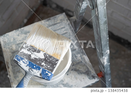 Paint brush and bucket on ladder, detail for indoor wall painting, renovation works, home improvement and interior finishing, decor prep. 138435438