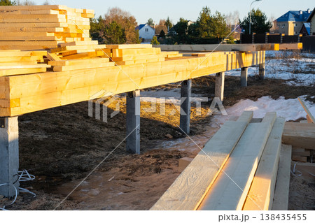 Timber frame house base on screw piles, mounting stage, foundation assembly, pile installation, carpentry, construction step, wood beams, site progress. 138435455