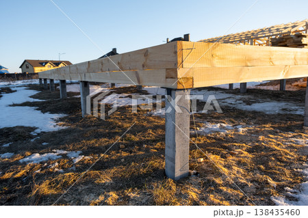 Timber frame construction on piles, substructure of base beams, site prep for house, mounting phase, carpentry assembly works, pile foundation, skeleton setup. 138435460