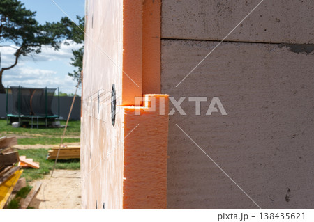 Thermal foam insulation on external wall, facade panel mounting, energy-efficient cladding, waterproofing, house renovation, construction site improvement, fixing adhesive. 138435621