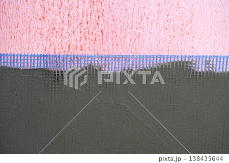 Plastering over mesh on outside wall, facade stucco, strengthening, protection for insulation, masonry works, external surface finishing, house construction. Plastering over mesh on outside wall, facade stucco, strengthening, protection for insulation, masonry works, external surface finishing, house construction. 138435644