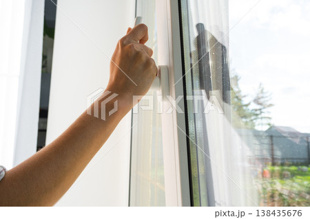 Open sash of plastic window, easy to operate white handle, demonstrates professional window installation, hardware adjustment prevents drafts, optimal acoustic insulation. Open sash of plastic window, easy to operate white handle, demonstrates professional window installation, hardware adjustment prevents drafts, optimal acoustic insulation. 138435676