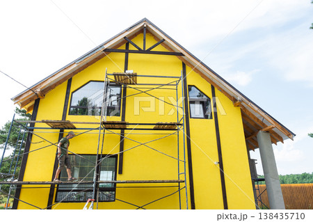 Yellow wall color over facade plaster, external wall finish, timber board decorative accent (half-timber decor), cladding, renovation and painting completed. Yellow wall color over facade plaster, external wall finish, timber board decorative accent (half-timber decor), cladding, renovation and painting completed. 138435710