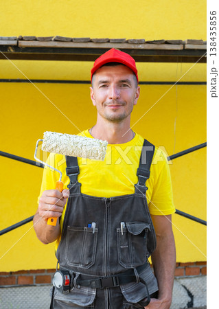 Portrait handyman with paint roller, ready for home painting, at-home repair project, private improvement business, tool kit, expert consultation, finishing works. Portrait handyman with paint roller, ready for home painting, at-home repair project, private improvement business, tool kit, expert consultation, finishing works. 138435856