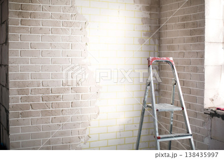 Interior wall finishing in home, preparation for painting or plastering, renovation, stepladder for working at height, professional repair and decoration. 138435997