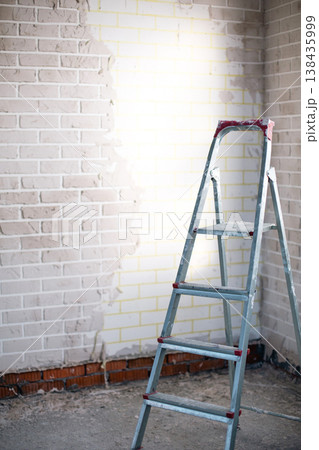 Room under renovation with stepladder, wall finishing, plaster and paint preparation, home improvement, indoor construction and interior remodeling project. Room under renovation with stepladder, wall finishing, plaster and paint preparation, home improvement, indoor construction and interior remodeling project. 138435999
