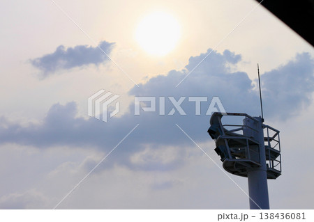 曇り空にそびえ立つスタジアムの照明塔と逆光の太陽 曇り空にそびえ立つスタジアムの照明塔と逆光の太陽 138436081