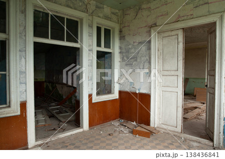 Abandoned Interior Room With Peeling Paint, Broken Windows, Wooden Doors, and Checkered Floor Showing Decay and Dilapidation Abandoned Interior Room With Peeling Paint, Broken Windows, Wooden Doors, and Checkered Floor Showing Decay and Dilapidation 138436841