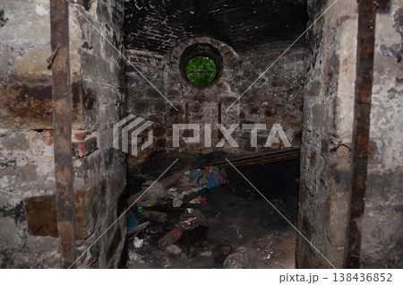Abandoned Brick Dungeon With Circular Green-Tinted Window And Debris Stacked Floor In Dark Rustic Texture Showing Decay And Neglect Over Time 138436852