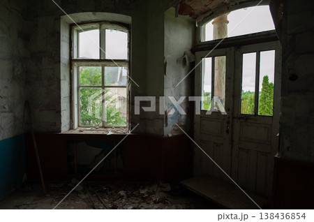 Abandoned Interior Room With Peeling Walls, Broken Windows And Debris Scattered Floor Showing Decay And Neglect In Muted Green And Blue Tones 138436854