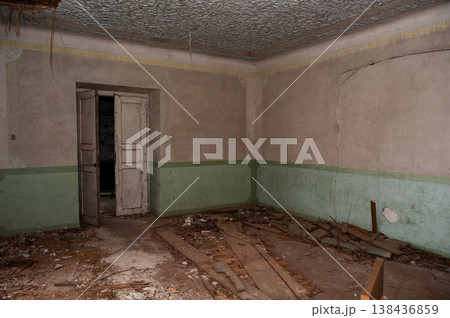 Abandoned Room With Peeling Green Paint Walls And Broken Wooden Floorboards Showing Decay And Neglect In Vintage Interior Setting 138436859