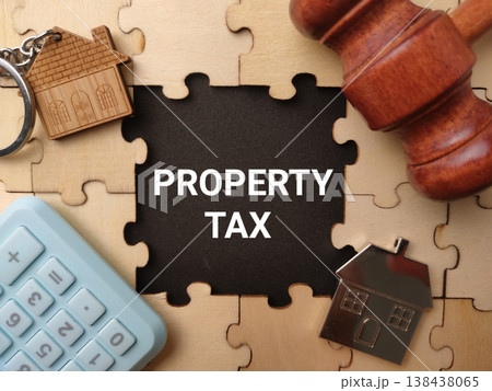 A conceptual flat lay photo featuring the text PROPERTY TAX on a dark center piece, surrounded by wooden puzzle elements. A conceptual flat lay photo featuring the text PROPERTY TAX on a dark center piece, surrounded by wooden puzzle elements. 138438065