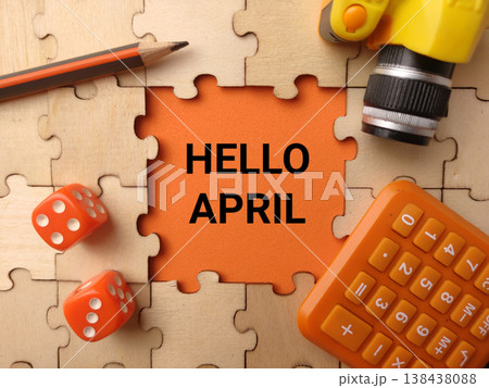 : A vibrant high-angle conceptual flat lay featuring the words HELLO APRIL on an orange background. : A vibrant high-angle conceptual flat lay featuring the words HELLO APRIL on an orange background. 138438088