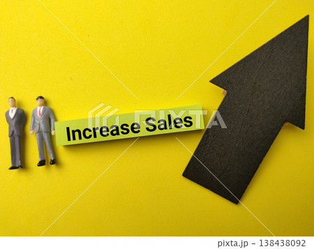 Vusinessmen standing next to a lime green sticky note with the text Increase Sales. Vusinessmen standing next to a lime green sticky note with the text Increase Sales. 138438092