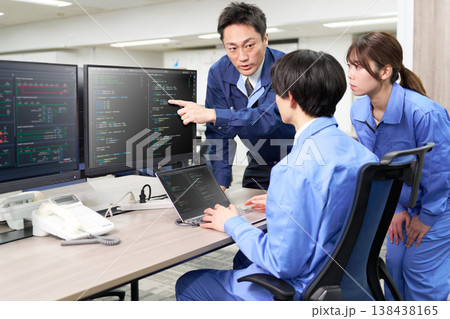 ベテラン技術者が若手と画面を共有しながらプログラム修正を行う現場 ベテラン技術者が若手と画面を共有しながらプログラム修正を行う現場 138438165