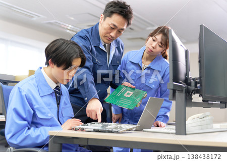 基板を見ながら学ぶ若手と指導する上司の技術研修 138438172