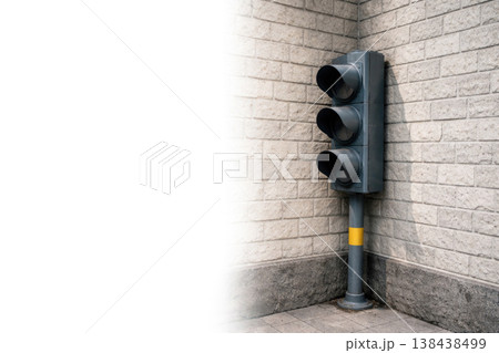 Inactive traffic light near a brick wall. Space for text. 138438499