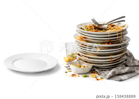 A stack of dirty plates next to a clean white plate. Space for text. 138438889