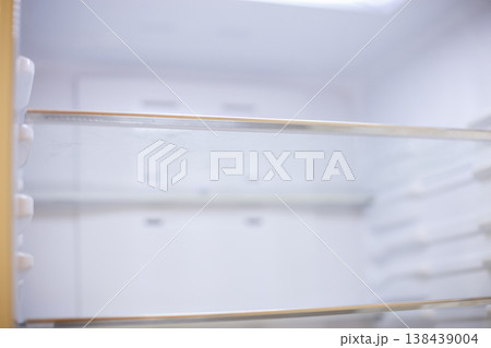 Empty refrigerator interior showing white shelves and lack of food Empty refrigerator interior showing white shelves and lack of food 138439004