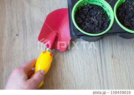 Gardening trowel filling pots with soil for planting Gardening trowel filling pots with soil for planting 138439019