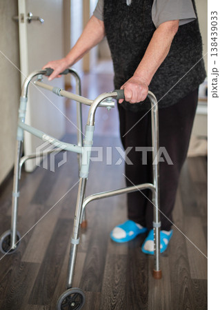 Senior woman walking at home in rehabilitation with medical walkers. 138439033