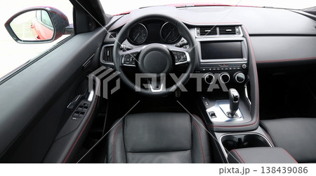 Look from drivers position on dashboard, steering wheel and leather stitched seat inside car Look from drivers position on dashboard, steering wheel and leather stitched seat inside car 138439086