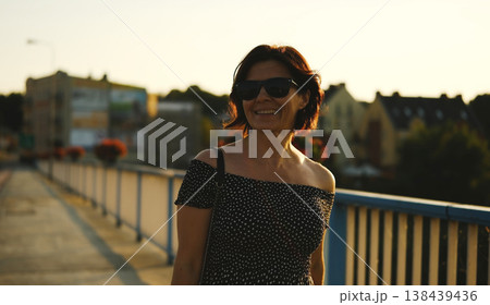 Attractive Young Woman Walks At Sunset. Happy Smiling Female Portrait At Sunset Attractive Young Woman Walks At Sunset. Happy Smiling Female Portrait At Sunset 138439436