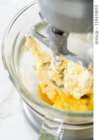 Detailed shot of whisk blending eggs in a glass mixing bowl, part of Easter Cookie Sandwich with Raspberry Buttercream process. Suitable for food blog imagery. 138439655