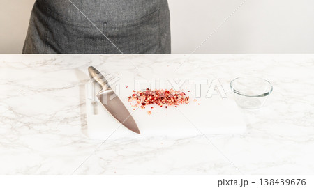 Fresh cranberries are finely chopped on a cutting board, prepared for adding to the cranberry buttercream in the lemon spritz cookie recipe. Fresh cranberries are finely chopped on a cutting board, prepared for adding to the cranberry buttercream in the lemon spritz cookie recipe. 138439676