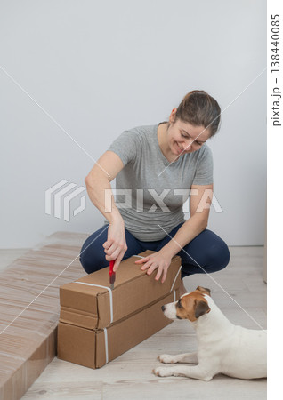 A Caucasian woman unpacks a box of furniture. A Caucasian woman unpacks a box of furniture. 138440085