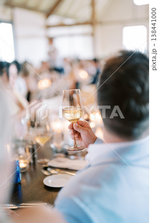 Man Raises Toast In Candlelit Lively Surroundings With Friends 138441000