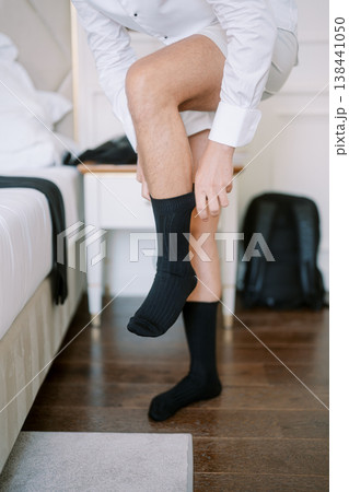 Caucasian Groom Pulling On Sock During Wedding Prep 138441050