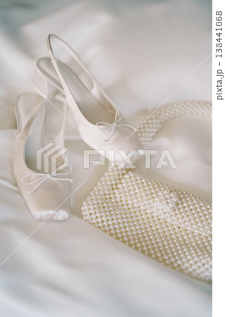 Chic Satin Shoes And Matching Clutch Featuring Bow And Pearl Adornments On Silk Background 138441068