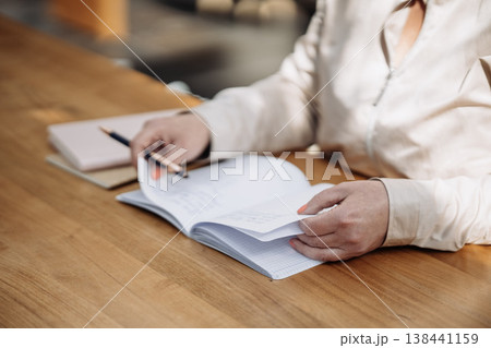 Hands Writing In Paper Notebook With Pen: Close Up Of Note Taking On Wooden Table In Natural Light. Copywriting 138441159