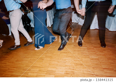 Casual Motion Captured Of Guests Dancing On Polished Wooden Floor During Happy Wedding Celebration Casual Motion Captured Of Guests Dancing On Polished Wooden Floor During Happy Wedding Celebration 138441315