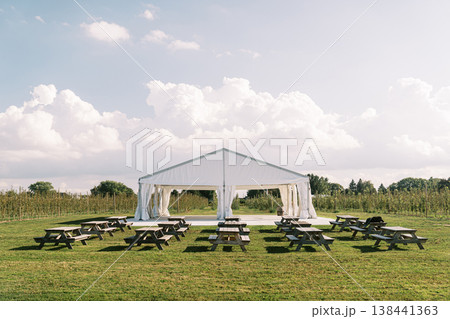 Relaxed Outdoor Venue Featuring Picnic Tables Under Sunny Sky 138441363